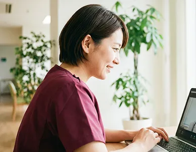 女性看護師がPCで仕事している様子の画像